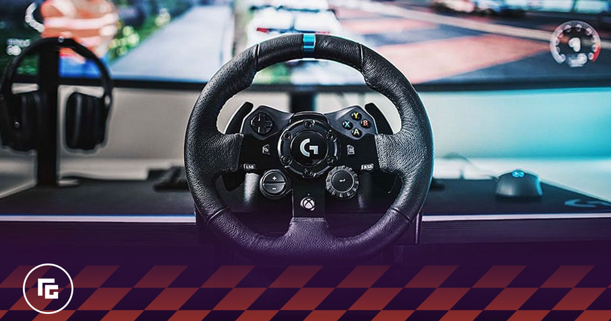 A black racing wheel with a blue centre line at the top in front of an ultrawide monitor.
