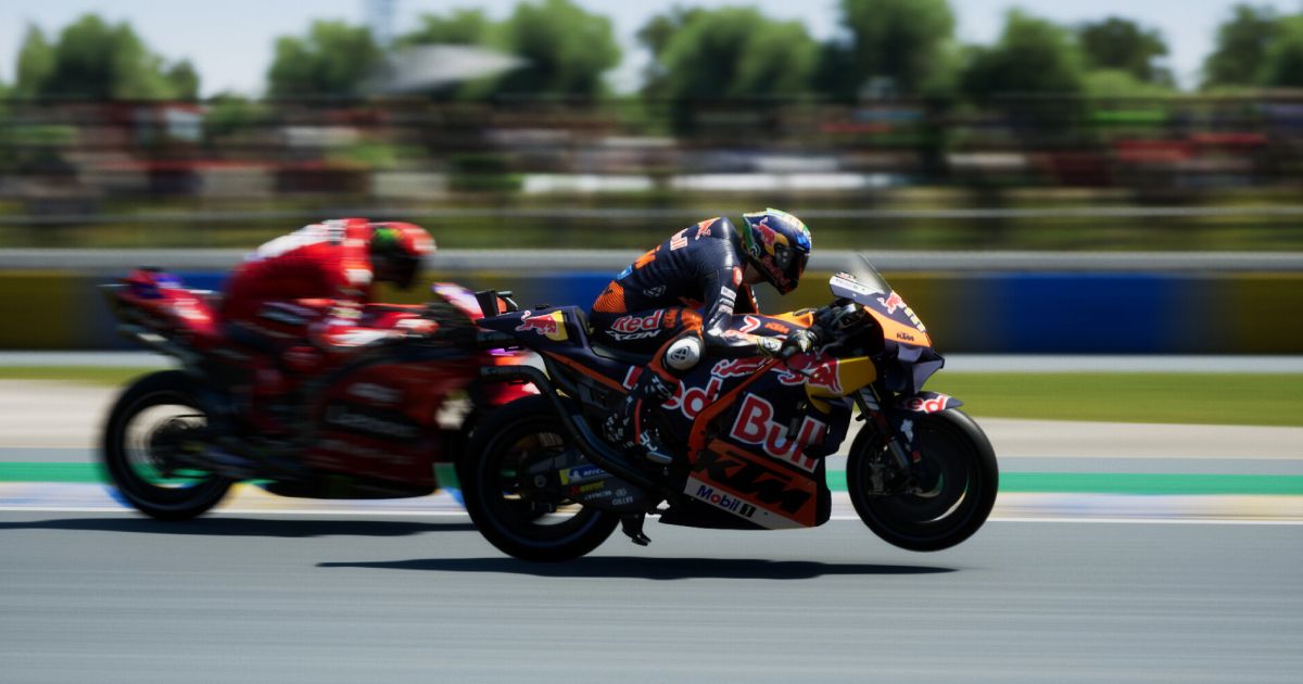 A dark blue Red Bull-branded motorbike racing on a track ahead of a red bike.