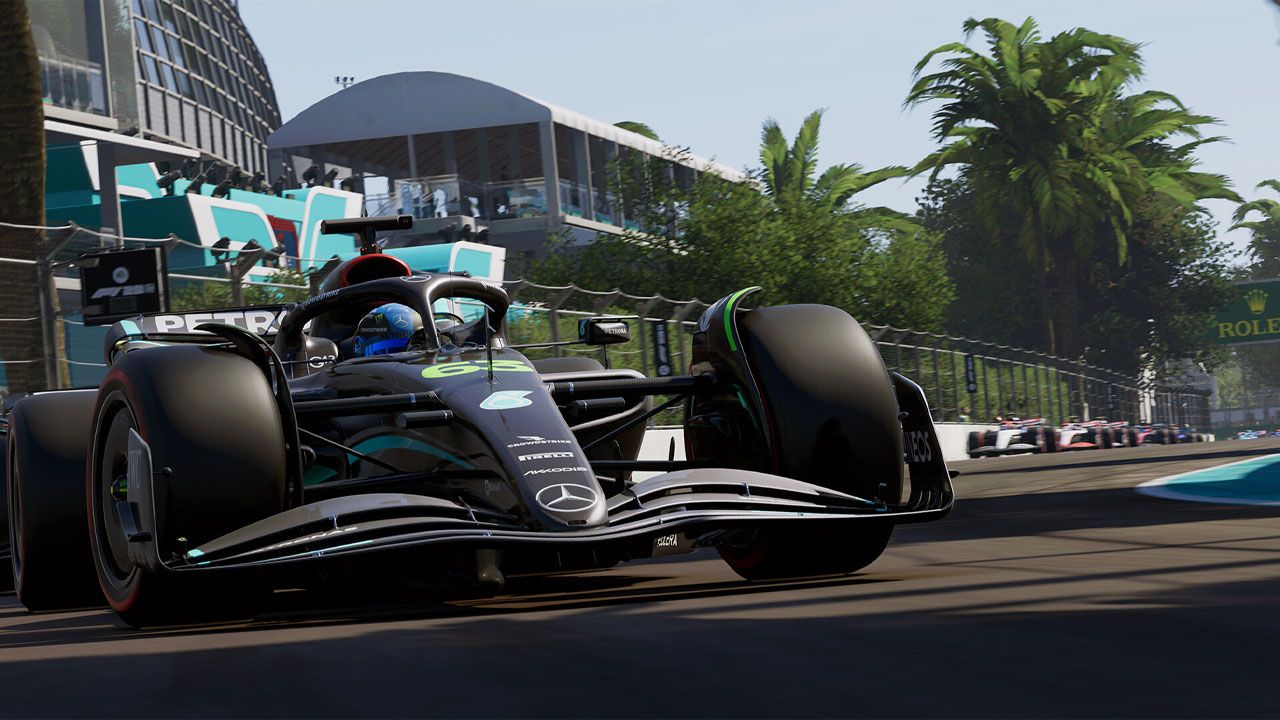 F1 23 in-game image of a black Mercedes car with light blue and green details on the track.
