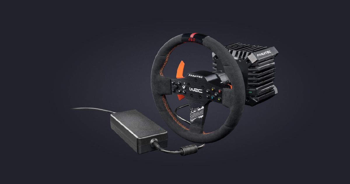 A black racing wheel with a fabric exterior, orange stitching, and metal centre console attached to a black wheel base.