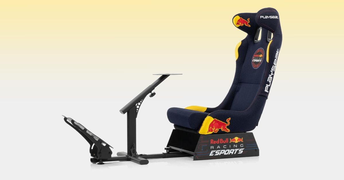 A black racing cockpit with a navy seat with red, yellow, and white Red Bull branding all over it.