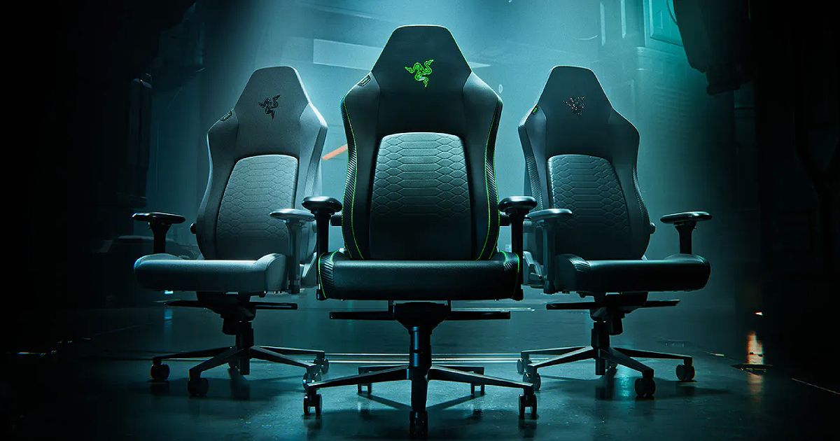 Three black gaming chairs lit up in blue in a dark room, all of which feature Razer branding in different colours at the top.