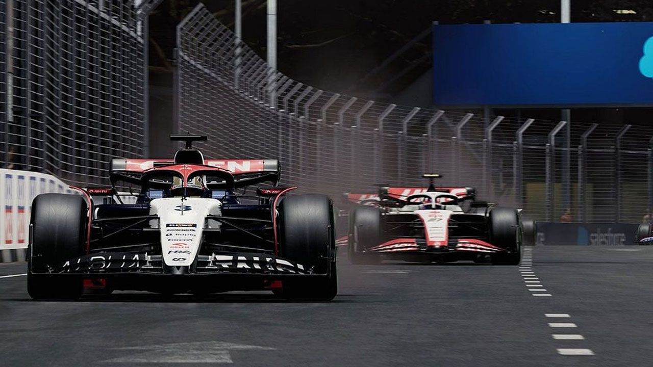 F1 23 in-game image of the white, red, and navy Alpha Tauri racing ahead of the Haas F1 car.
