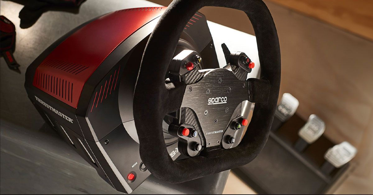A close-up of a black racing wheel featuring red buttons on the console and a black and red wheel base.