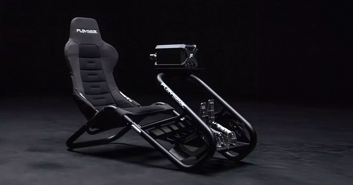 A black racing seat attached to a black-framed wheel and pedal stand featuring white branding.
