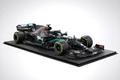 A model of the black and light blue Mercedes F1 car on a black podium.